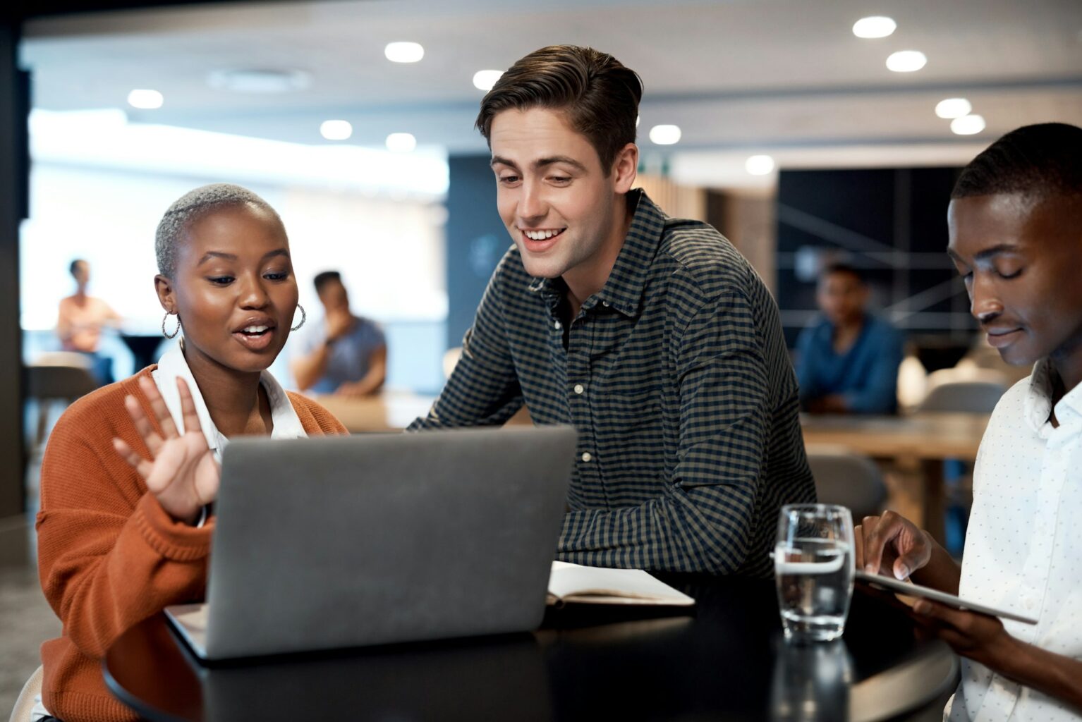 Shot of a group of young businesspeople using a laptop during a conference in a modern office